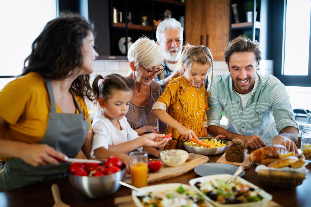 Cheerful happy family spending good time together while cooking in kitchen