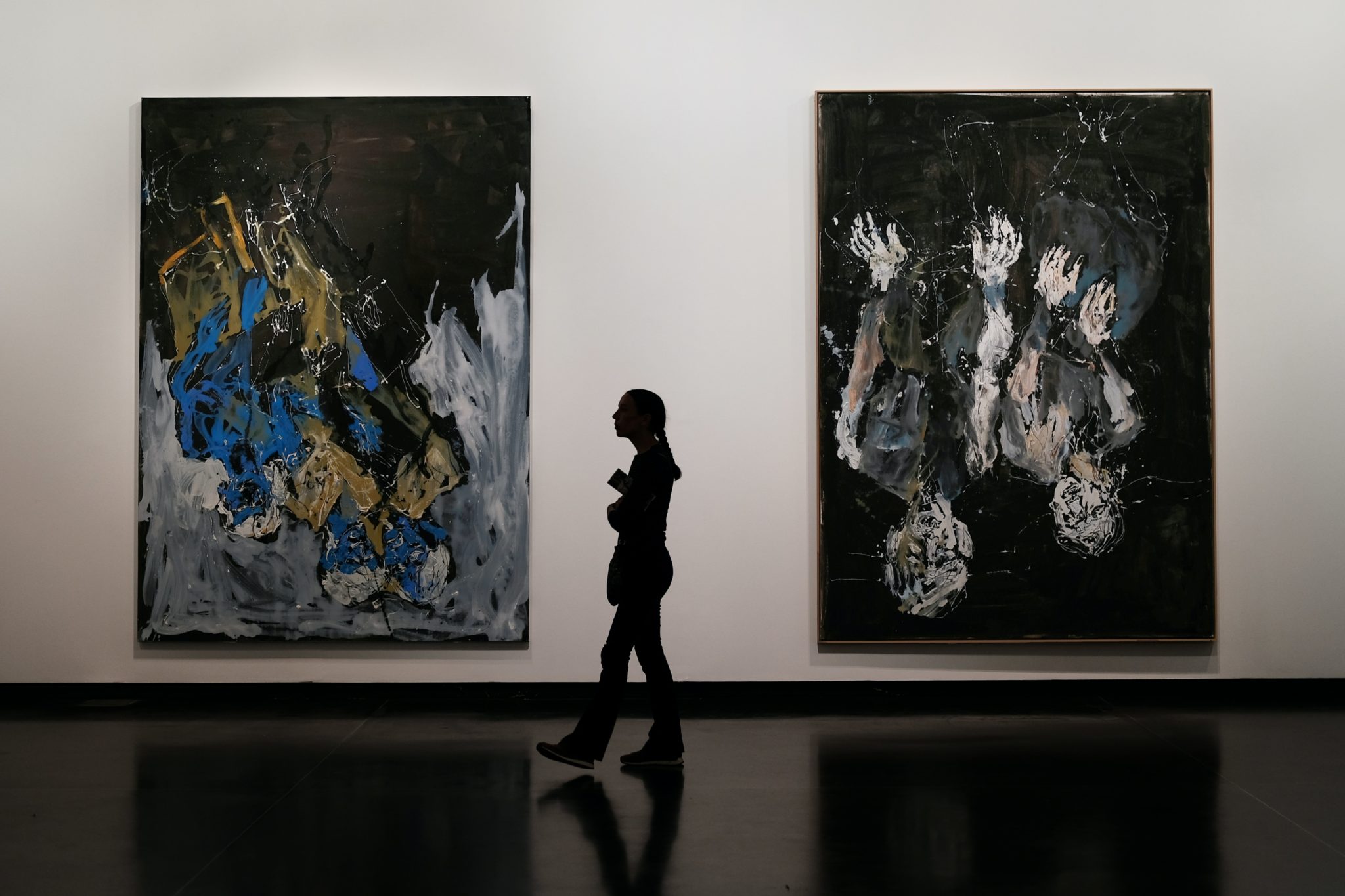 silhouette of person in front of abstract paintings